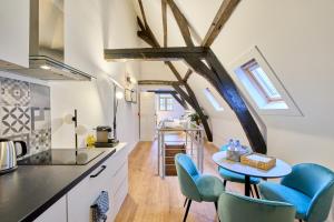 a kitchen with blue chairs and a table in a room at Maison Grand Place Studio 6 in Brussels
