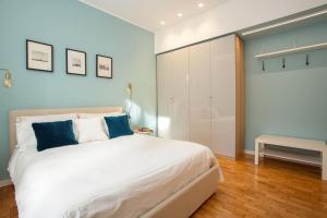 a bedroom with a large white bed with blue pillows at Santa Chiara Suite in Turin