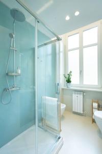 y baño con ducha acristalada y lavamanos. en Santa Chiara Suite en Turín