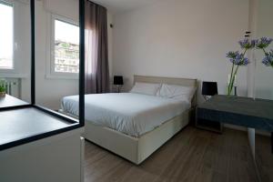 a bedroom with a bed and a table with a window at Residenza Ca'Fe in Treviso