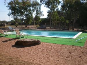 een zwembad met twee stoelen en een tafel bij Stazzo Gallurese La Cugara in Aglientu