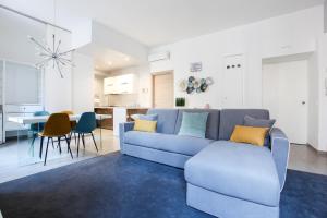 un soggiorno con divano blu e una cucina di Modern apartment close to shopping district a Milano