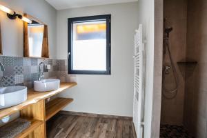 レ・ゾルにあるChalet Le Loup Blancの洗面台が2つと窓があるバスルーム