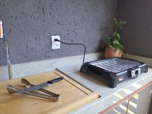 a grill sitting on a counter next to a cutting board at Praia do Patacho - Milagres in Pôrto de Pedras +23 photos