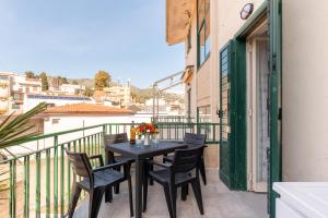 una mesa y sillas en el balcón de un edificio en La Casa Di Tobia Central Flat near the Sea en Giardini Naxos