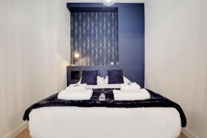 a bedroom with a large white bed with blue walls at CMG Charmant appartement 1BR/4P - République / Temple in Paris