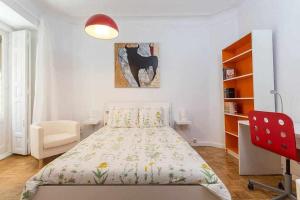 a bedroom with a bed and a red chair at Piso confortable y céntrico in Madrid