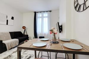 a living room with a table with plates and flowers on it at CMG Charmant appartement 1BR/4P - République / Temple in Paris