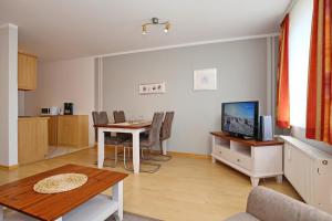 a living room with a dining room table and a kitchen at Sünnslag Wohnung 057 in Boltenhagen