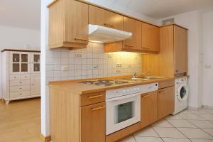 a kitchen with wooden cabinets and a stove top oven at Sünnslag Wohnung 057 in Boltenhagen