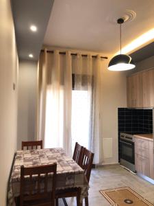 a kitchen with a table and chairs and a window at The only luxurious apartment in the center of town in Kilkis