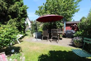 un patio con mesa, sillas y sombrilla en Ferienhaus Beyer en Kühlungsborn