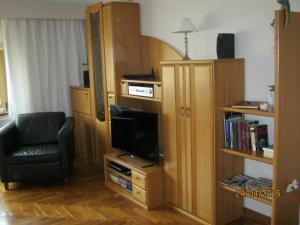 ein Wohnzimmer mit einem TV und einem Stuhl in der Unterkunft Ferienwohnung Dünensand in Kühlungsborn