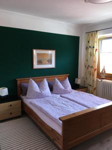 a bedroom with a large bed with a green wall at Ferienwohnung Dünensand in Kühlungsborn