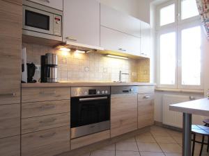 eine Küche mit Holzschränken und einer Mikrowelle in der Unterkunft Ferienwohnung Seeadler Nr. 7 in Kühlungsborn