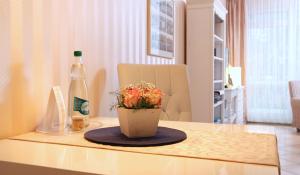 a bottle of wine and a vase with flowers on a table at Ferienwohnung Antonia in Kühlungsborn