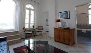 ein Wohnzimmer mit einem Couchtisch aus Glas und einem Tisch in der Unterkunft Haus Bischofsstab - Ferienwohnung am Meer in Heiligendamm