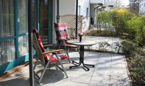 2 Stühle und ein Tisch auf der Terrasse in der Unterkunft Ferienwohnung Antonia in Kühlungsborn