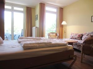 FulgenにあるFerienwohnung Marianneのベッドルーム1室(ベッド1台、ソファ、テーブル付)