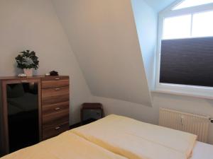 a bedroom with a bed and a window and a dresser at Ferienwohnung Ingeborg in Kühlungsborn