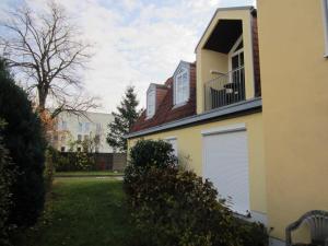 ein gelbes Haus mit einem Fenster und einem Balkon in der Unterkunft Ferienwohnung Ingeborg in Kühlungsborn