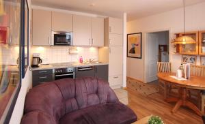 eine Küche und ein Wohnzimmer mit einem Sofa und einem Tisch in der Unterkunft Ferienwohnung Parkblick Nr. 25 in Kühlungsborn