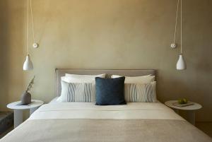a bedroom with a large bed with two side tables at PAROCKS Luxury Hotel & Spa in Ambelas