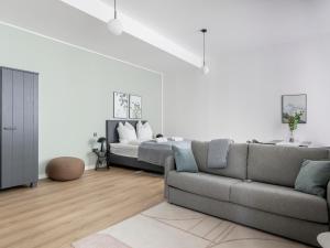 a living room with a couch and a bed at Limehome Rosenheim Gillitzerstraße in Rosenheim