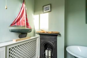 a bathroom with a fireplace with a boat on the wall at 7 St John's Crescent in York +19 photos