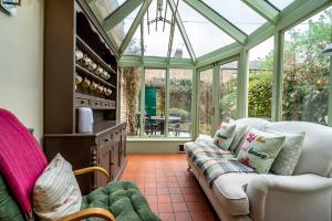 a conservatory with a couch in a room with windows at 7 St John's Crescent in York