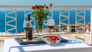 una mesa con dos copas de vino y un tazón de fresas en Apartments and Room Lora, en Dubrovnik