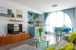 Apartments and Room Lora في دوبروفنيك: غرفة معيشة مع أريكة وتلفزيون وطاولة