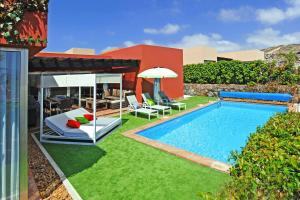 a backyard with a swimming pool and a house at Salobre Par 4 No6 in Salobre