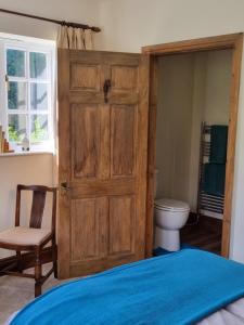a bedroom with a wooden door and a toilet at Willowcroft in Alkborough