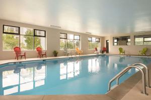 a pool in a hotel with red chairs and tables at Super 8 by Wyndham Nashville Airport North in Nashville