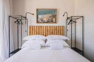 a bedroom with a large bed with white pillows at MUTE Hostel Porto Covo in Porto Covo