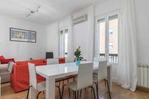 een woonkamer met een witte tafel en een rode bank bij Agradable piso de dos habitaciones en Chamberí in Madrid