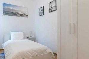 ein weißes Schlafzimmer mit einem Bett und einem Schrank in der Unterkunft Agradable piso de dos habitaciones en Chamberí in Madrid
