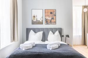 um quarto com uma cama grande e almofadas brancas em limehome Rosenheim Gillitzerstraße em Rosenheim