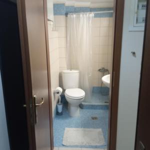 a bathroom with a toilet and a sink at HOME in Patra