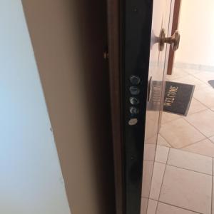 uma porta de vidro com uma maçaneta de porta num quarto em HOME em Patra