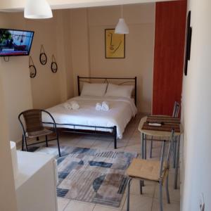 sypialnia z łóżkiem, stołem i krzesłami w obiekcie HOME w mieście Patras