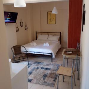 sypialnia z łóżkiem, stołem i krzesłami w obiekcie HOME w mieście Patras