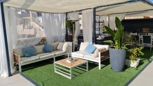 un porche con 2 sofás, una mesa y plantas en Villa Peer ללא מסיבות או מוסיקה, en Eilat