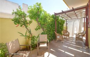 a patio with chairs and tables and trees at Villa Cristiana in Scoglitti