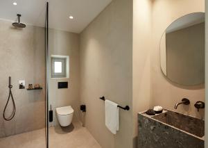 a bathroom with a shower and a toilet and a sink at PAROCKS Luxury Hotel & Spa in Ambelas
