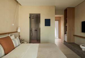a bedroom with a large bed and a bathroom at PAROCKS Luxury Hotel & Spa in Ambelas