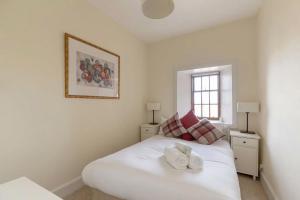 Un dormitorio con una cama blanca con dos toallas encima. en Stunning Panoramic Views: Heart of the Royal Mile, en Edimburgo