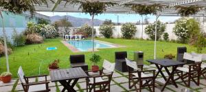 a patio with tables and chairs and a pool at Open Hotel in Quillota