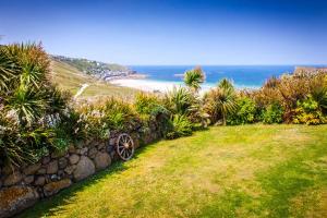 a stone wall with a view of the ocean at The Studio Cottage, with, Sea views, Garden, Amazing Location by beach in Sennen